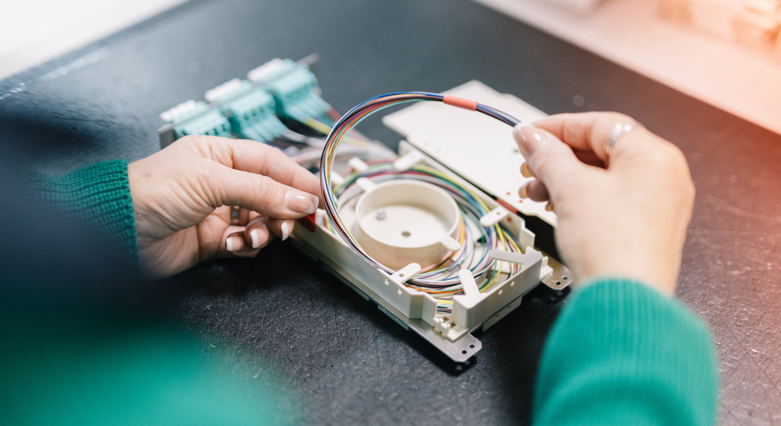 Zwei Hände setzten Kabel in Baugruppenträger ein, EFB-Elektronik